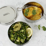 A top down image of the A slice of green chapra two tier round lunchbox  with food inside
