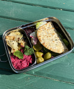 A close up of the A slice of green large lunchbox with mini container on a wooden table with various food items inside