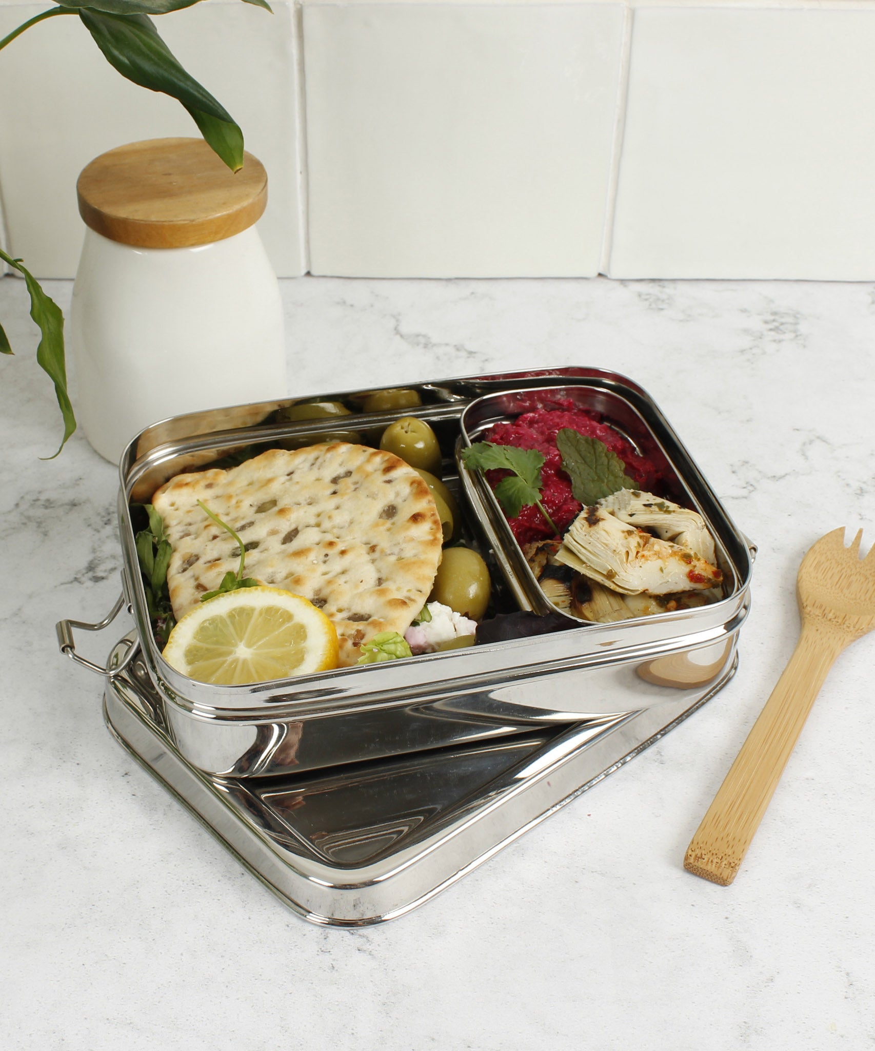 A slice of green large lunchbox with mini container available at Babipur standing on a kitchen worktop