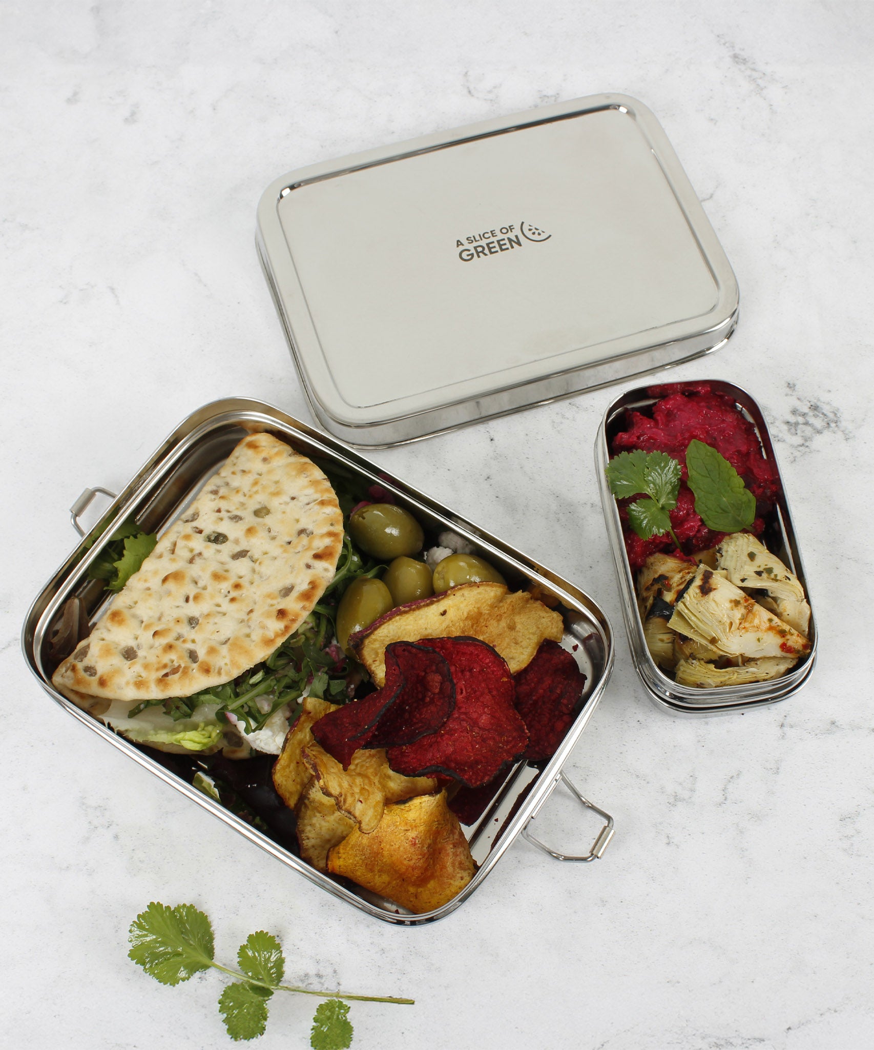A top down image of the A slice of green large lunchbox with mini container showing different food items inside the main and mini compartment