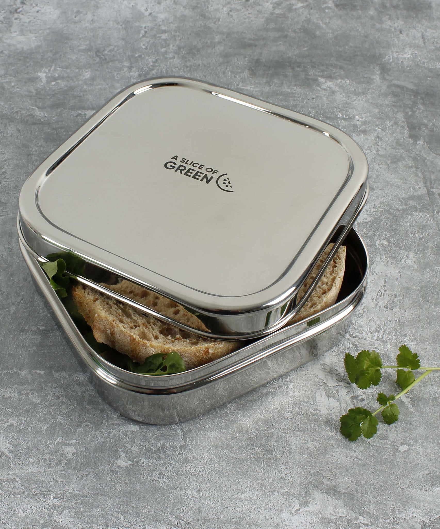 A close up of the A slice of green shimla large square container lunchbox showing the stainless steel finish detail