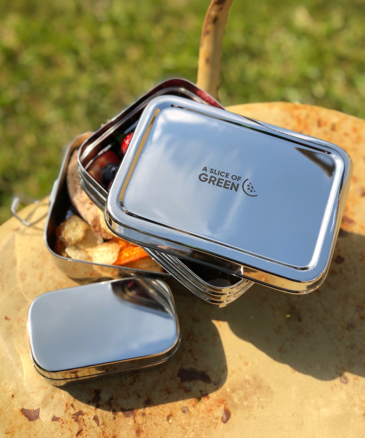 A close up of the A slice of green two tier lunchbox with mini container showing the stainless steel finish detail