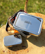 A close up of the A slice of green two tier lunchbox with mini container showing the stainless steel finish detail