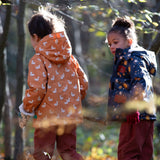 Back of boy playing in a forest wearing a hooded Little Green Radicals Waterproof Winter School Coat, made from recycled bottles, with a yellow gold duck print, for sale at Babipur.
