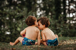 Two babies wearing The Close Pop-In x Babipur exclusive reusable nappy wrap, in a Babipur Dan y Ser print