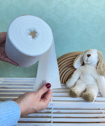 Hand holding a roll of Disposable Paper Nappy Liners for reusable nappies by Bambinex, available to buy at Babipur.