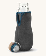 A close up of the Black + Blum glass bottle with active charcoal water filter and locking coil showing the felted holder and lid detail