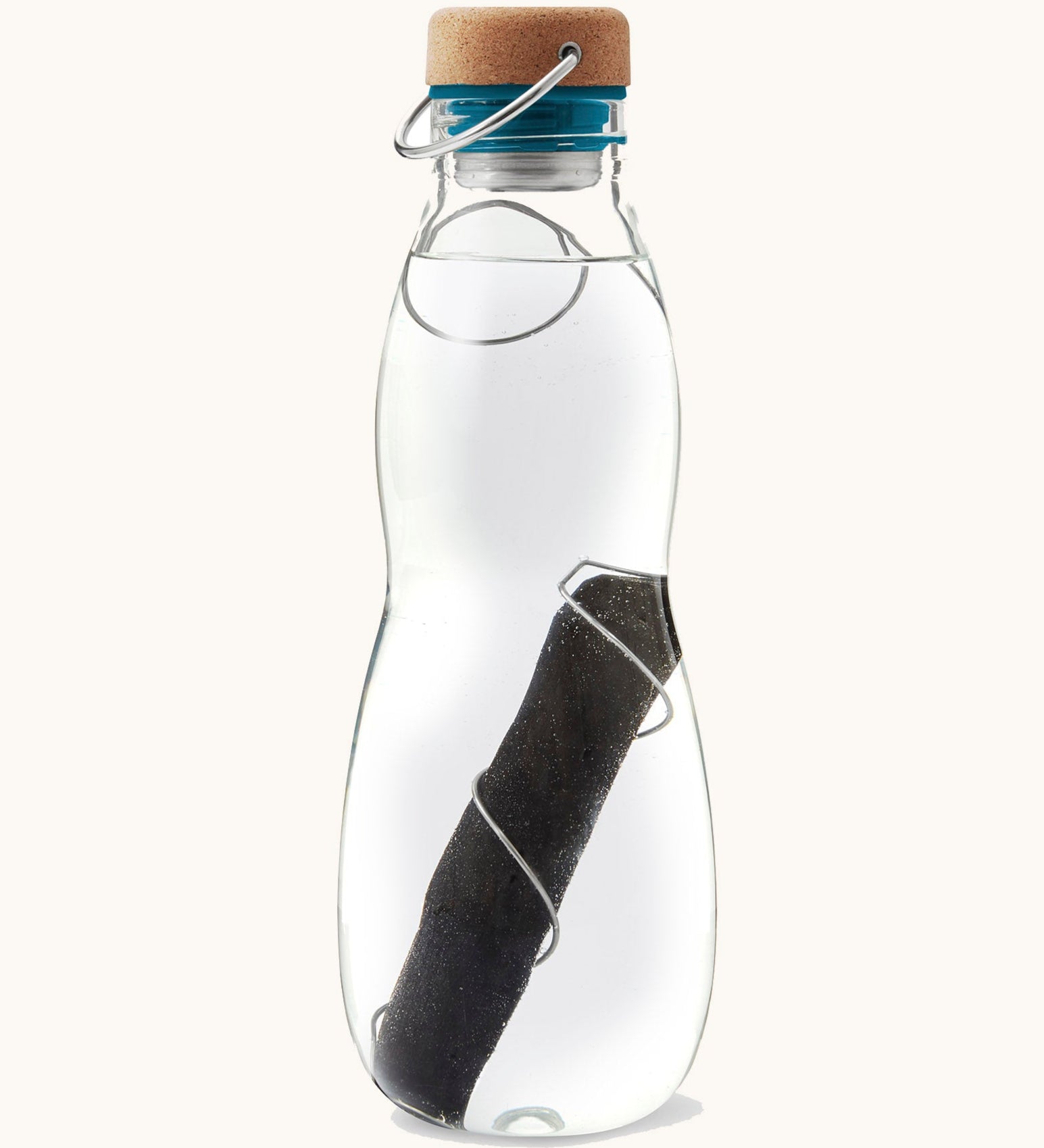 A close up of the Black + Blum glass bottle with active charcoal water filter and locking coil showing the charcoal filter detail