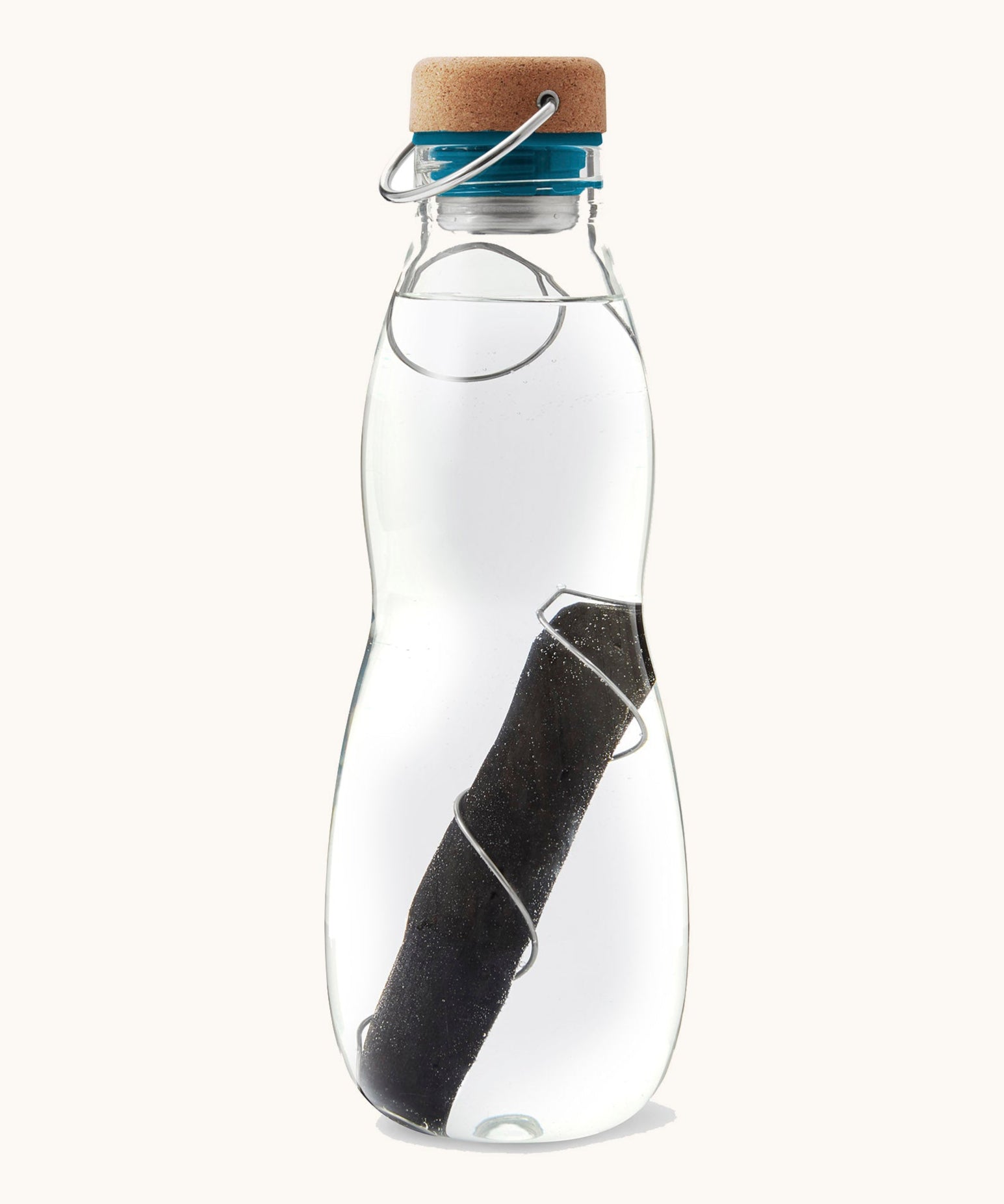 A close up of the Black + Blum glass bottle with active charcoal water filter and locking coil showing the charcoal filter detail