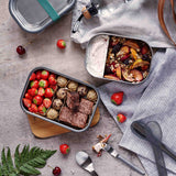 A top down view of the different Black + Blum leakproof stainless steel lunchboxes with food inside