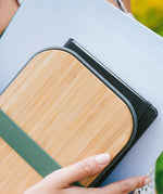 A close up of a sandwich in a Black + Blum stainless steel airtight sandwich box showing the bamboo lid detail