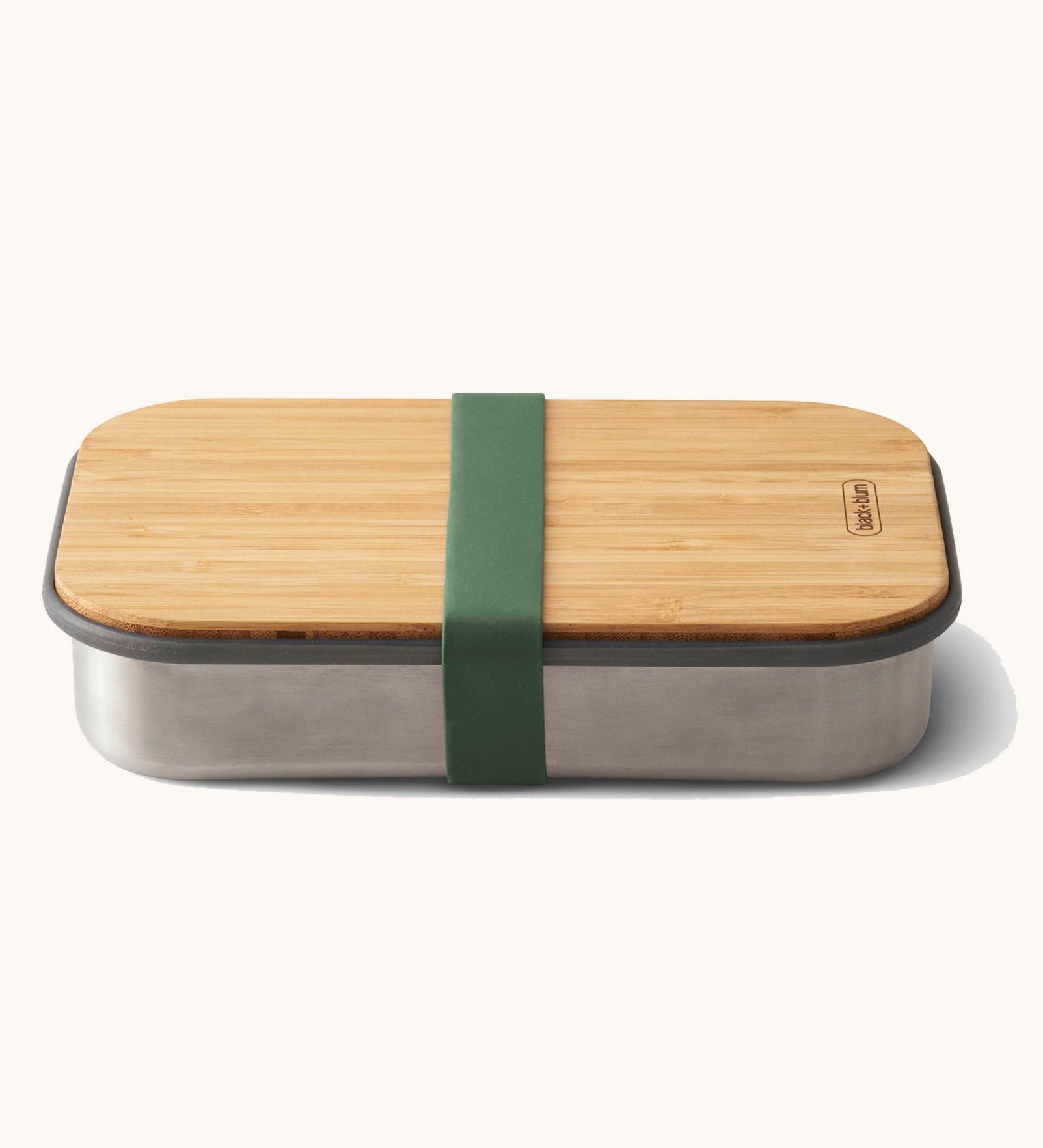 Black + Blum stainless steel airtight stainless steel sandwich box with a olive silicone holder available at Babipur. Features a bamboo lid which can be used as a prep surface or plate.