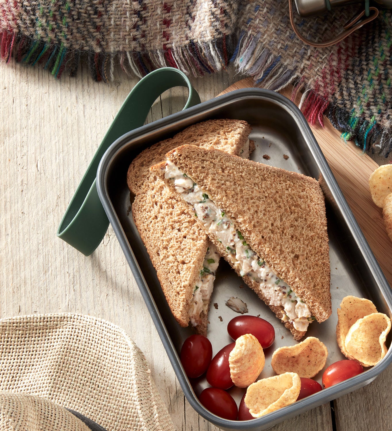 A close up of a sandwich in a Black + Blum stainless steel airtight stainless steel sandwich box