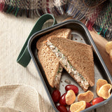 A close up of a sandwich in a Black + Blum stainless steel airtight stainless steel sandwich box
