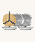 A close up of the Black + Blum set of 4 stainless steel plates showing the protective bamboo lid and plate detail