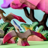 Bumbu Wooden Pteranodon Dinosaur. The toy sits within a Jurrasic setting with another Pteranodon.