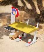 The Candylab Rocket Fuel Station under the shade of a cactus with a desert background