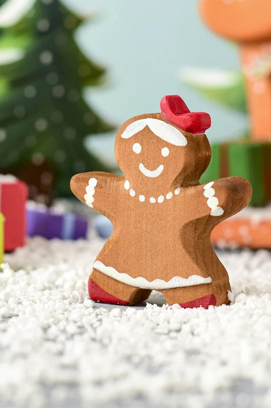 Gingerbread woman by Bumbu toys figurine with a red hat on a snowy background