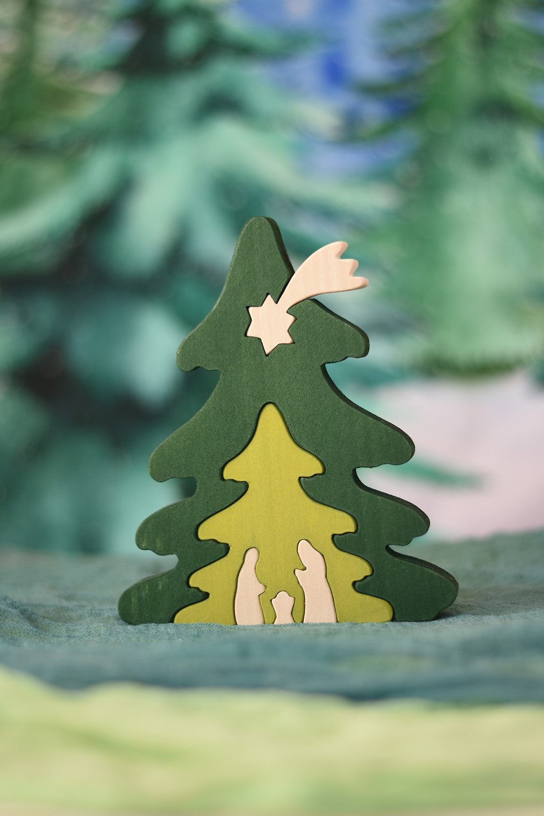 Decorative wooden Christmas tree ornament with a star on a soft surface with blurred green background