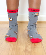A close up of a child wearing the Eco kiddies organic cotton chirpy robbins socks showing the cute robin design and red trim detail