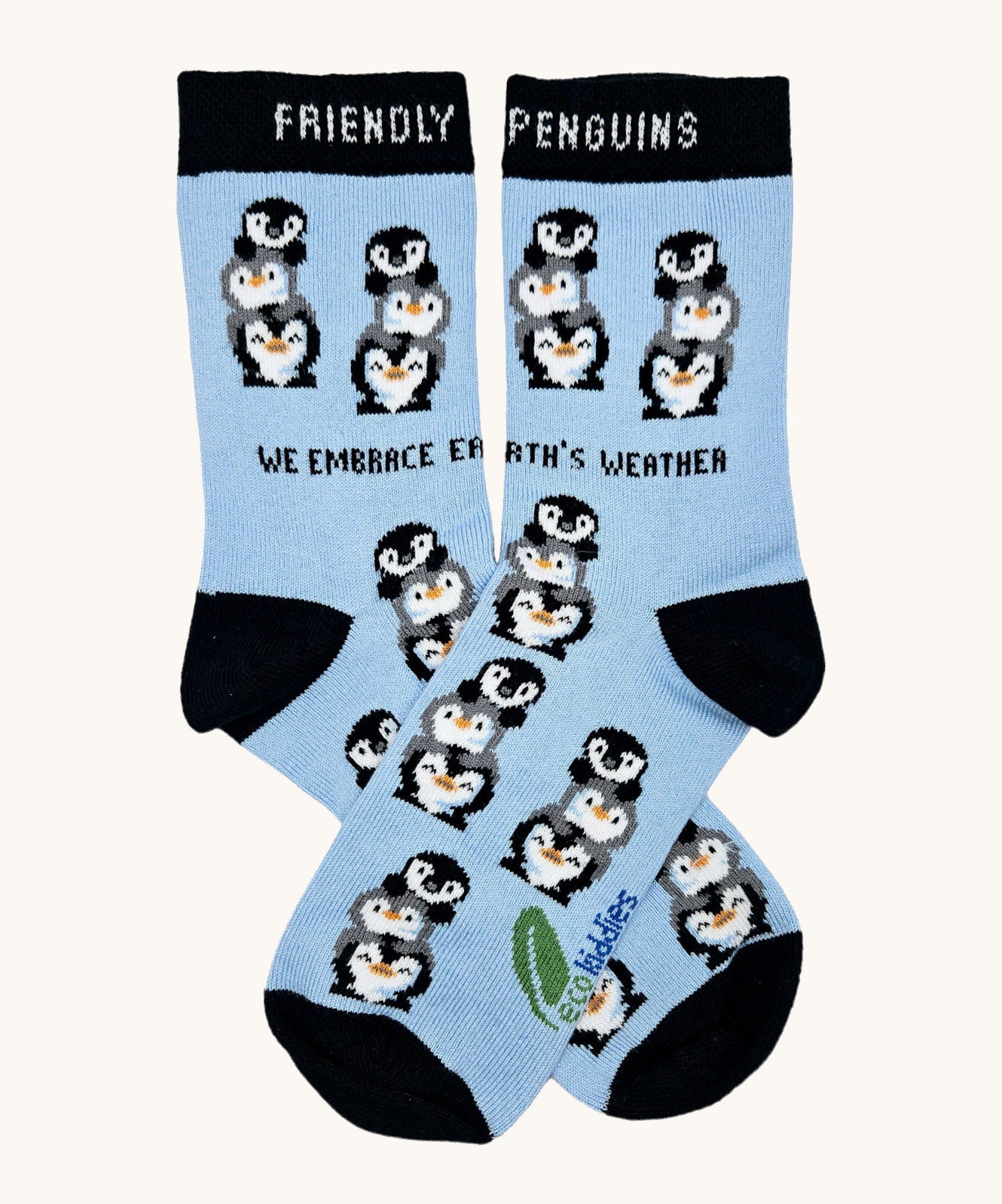 Eco kiddies friendly penguins organic cotton kids socks. A light blue sock with black trim and features cute playful penguins with a slogan saying 'we embrace earth's weather'