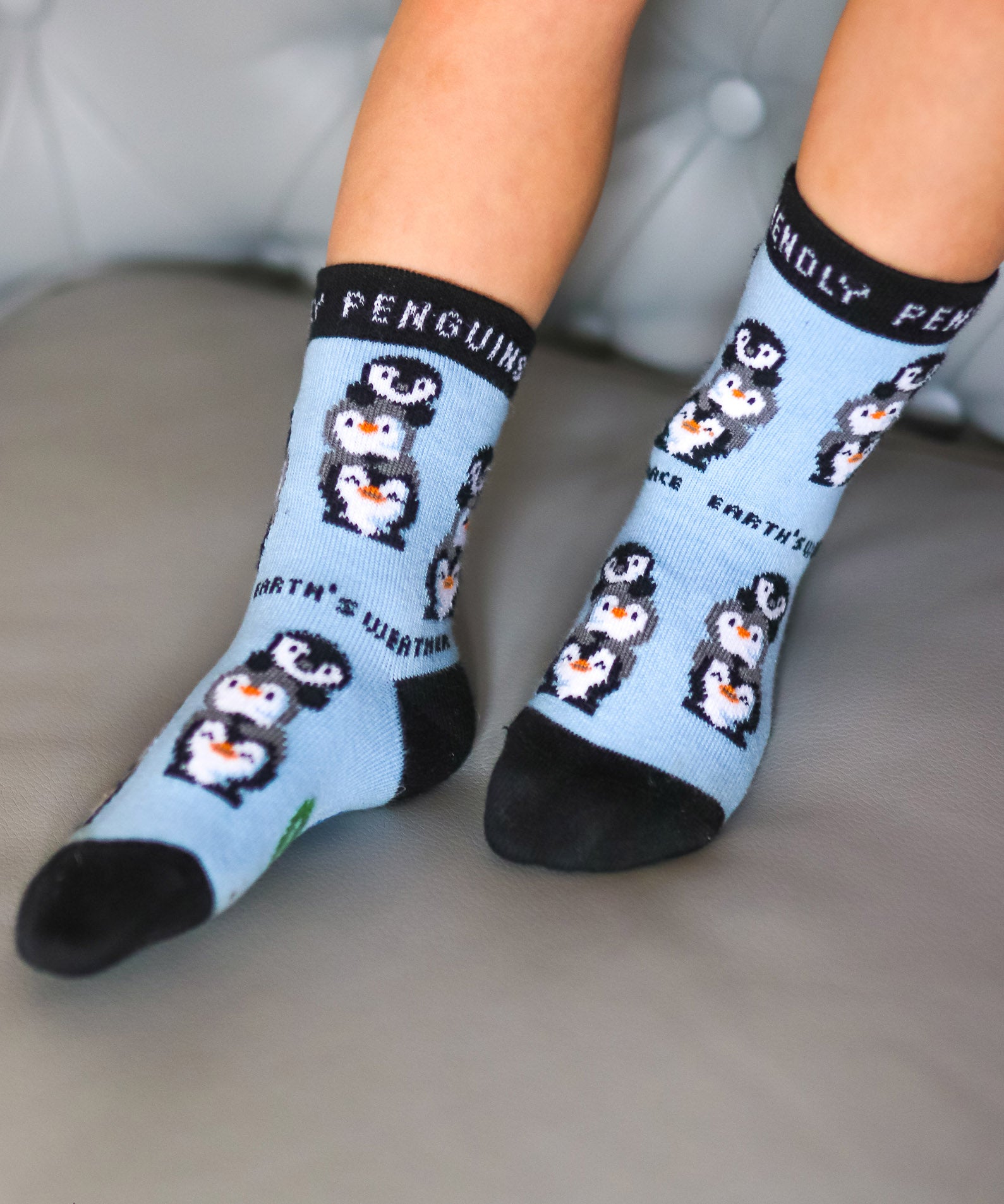 A close up of a child wearing the Eco kiddies organic cotton friendly penguins socks showing the cute playful penguin design detail