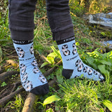 A child standing on branches and wearing the Eco kiddies organic cotton friendly penguins light blue socks