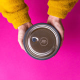 An adult hand holding the Elephant box medium lunchbowl against a bright pink background. Lunchbowl available at Babipur.