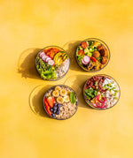 A top down image of the different Elephant box lunch bowls with the lids off and full of different healthy foods.