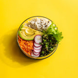A top down image of the medium Elephant box lunch bowl available at Babaipur. Bowl on a bright yellow background with the lids off and full of different healthy foods.