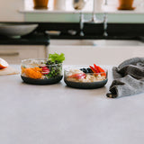 The large and medium Elephant box lunch bowls on a kitchen counter with the lids off and full of different healthy foods. Both bowls are available at Babipur.