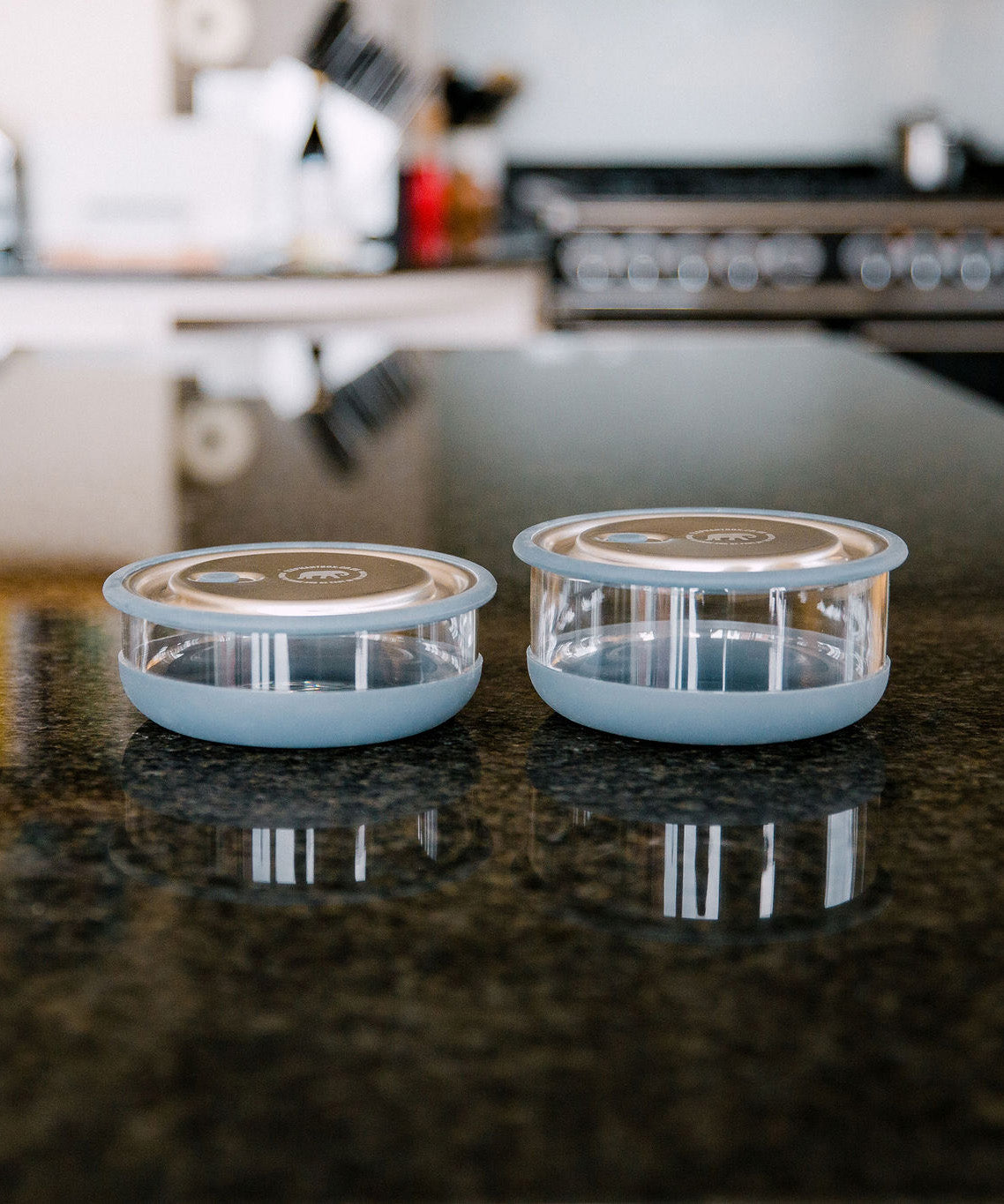 A Elephant box medium lunch bowl in a kitchen setting and standing next to the large lunch bowl as a size comparison. Both bowls are available at Babipur.