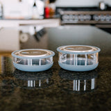 A Elephant box medium lunch bowl in a kitchen setting and standing next to the large lunch bowl as a size comparison. Both bowls are available at Babipur.