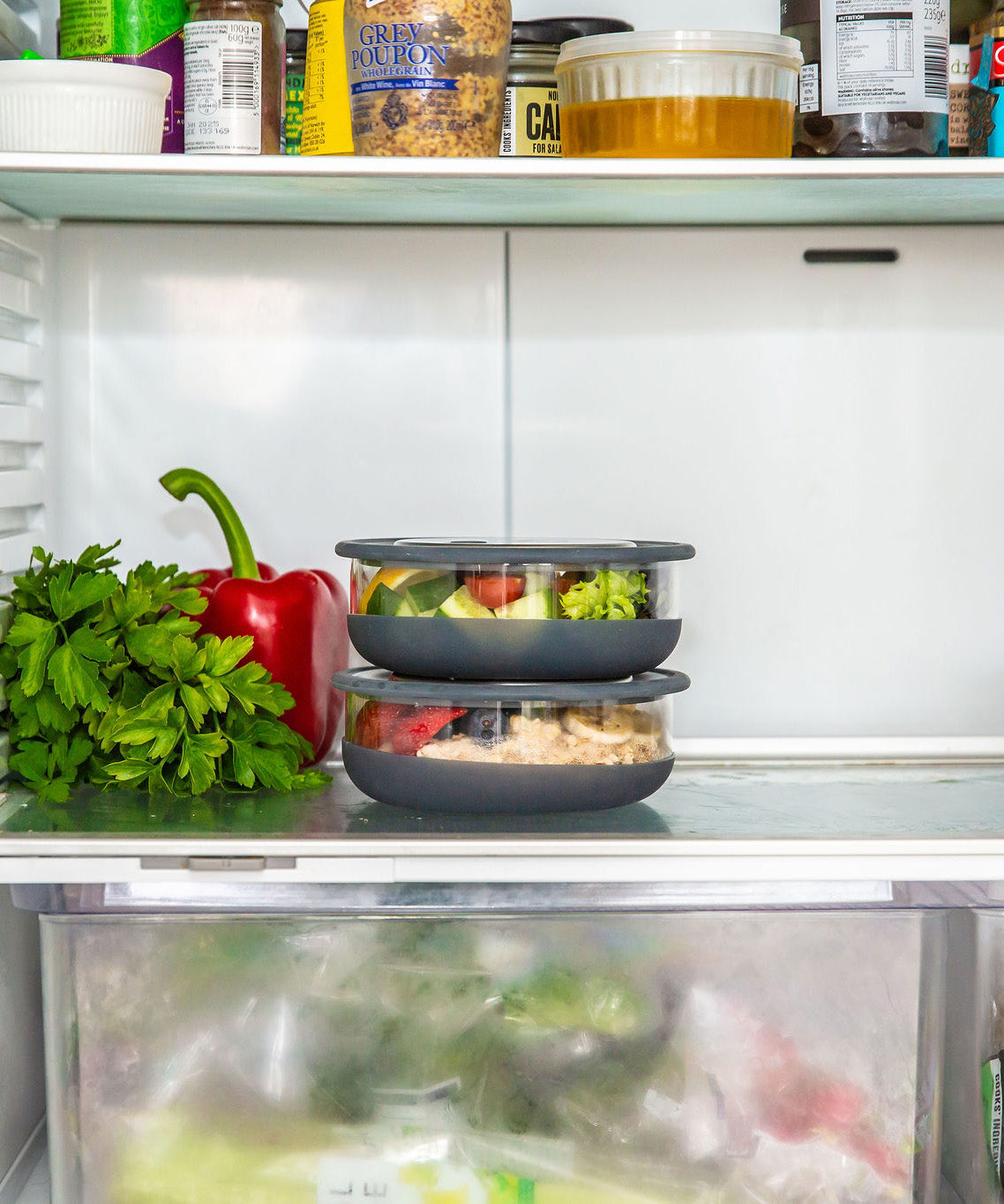 A stack of medium  Elephant box lunch bowls in a fridge and packed with different foods. This bowl is available at Babipur.