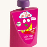 Erzi Wooden Squeezy Cherry & Banana Fruit Pouch. A bright pink wooden pouch, with a purple top, with a fun graphic banana and cherry label. On a Cream background