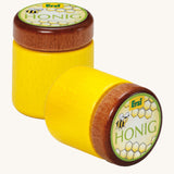 Two Erzi Wooden Honey Jar, one stood up and one laying down, on a cream background
