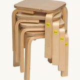 A stack of Erzi Toy stool ontop of each other, with the Erzi logo on the leg. Great for small storage spaces!