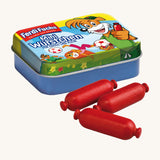 Erzi Wooden Mini Sausages In A Tin. 3 mini wooden sausages in a dark red colour are placed in front of a colourful mini sausages tin. On a cream background