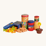 A closer look at the Erzi Wooden Party Food Set which includes pasta, party sausages, tomato sauce, apple juice, a cupcake and candle. On a cream background