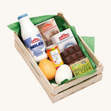 Erzi Wooden Assorted Baking Ingredients. A selection of wooden Erzi baking ingredients, in a wooden Erzi crate and green paper. On a cream background