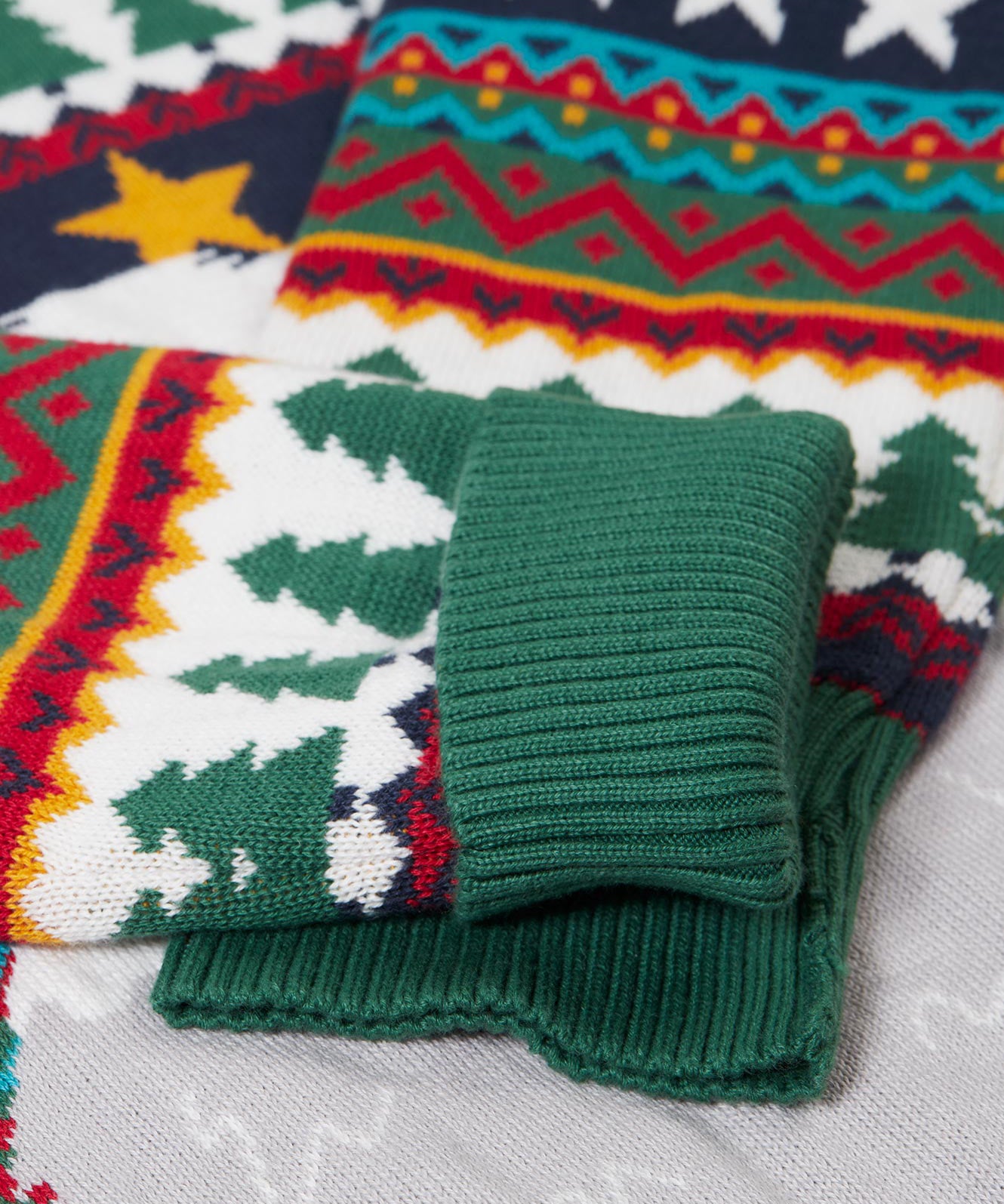A close up of the green arm cuffs on the Frugi forest fairisle/yeti jumper available at Babipur.