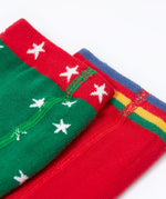 A close up of the waistbands on the Frugi Norah tights in green robin and berry red 2 pack available at Babipur. A pair of GOTS organic cotton tights in green with white stars and a robin design. Other pair is a bright festive red.