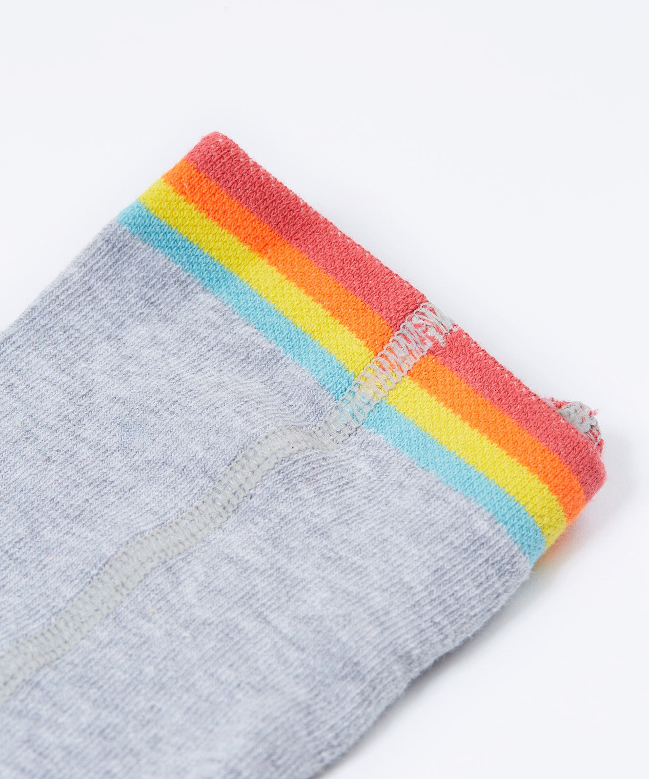 A close up of the rainbow stripe waistband on the Frugi Norah tights in grey marl / rainbow available at Babipur. A GOTS organic cotton grey tights with a playful rainbow design and red contrasting heel and toe panels.