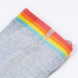 A close up of the rainbow stripe waistband on the Frugi Norah tights in grey marl / rainbow available at Babipur. A GOTS organic cotton grey tights with a playful rainbow design and red contrasting heel and toe panels.