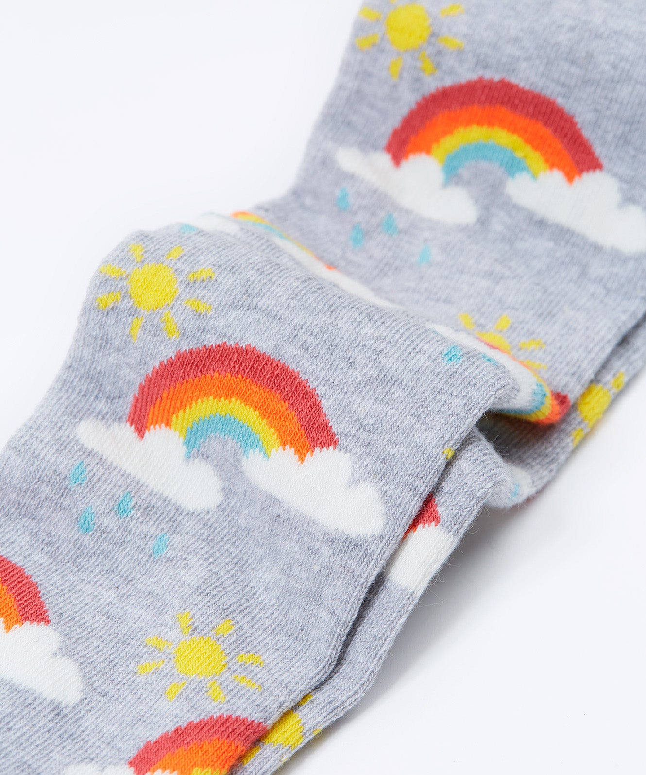 A close up of the rainbow print on the Frugi Norah tights in grey marl / rainbow available at Babipur. A GOTS organic cotton grey tights with a playful rainbow design and red contrasting heel and toe panels
