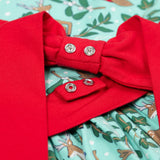A close up of the red bow that can be poppered onto the back of the Frugi party skater dress in festive forest available at Babipur. A GOTS organic cotton dress in mint green with a playful winter / festive print. Features a red tie around the waist