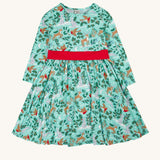 Frugi party skater dress in festive forest available at Babipur. A GOTS organic cotton dress in mint green with a playful winter / festive print. Features a red tie around the waist