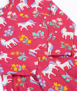 A close up of the Frugi sofia skater dress in rose / unicorn floral available at Babipur. A GOTS organic cotton dress in light pink with a cute unicorn and floral design.
