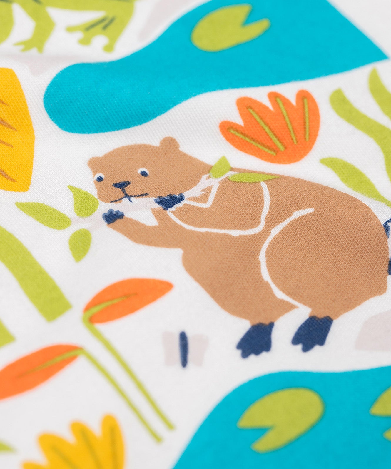 A close up of the beaver on the Frugi tamar raglan top in soft white/waterways available at Babipur. A orange and white GOTS organic cotton long sleeve top with a playful waterways print on the front.