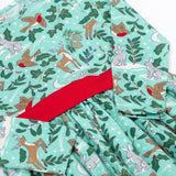 A close up of the front of the Frugi party skater dress in festive forest available at Babipur. A GOTS organic cotton dress in mint green with a playful winter / festive print. Features a red tie around the waist